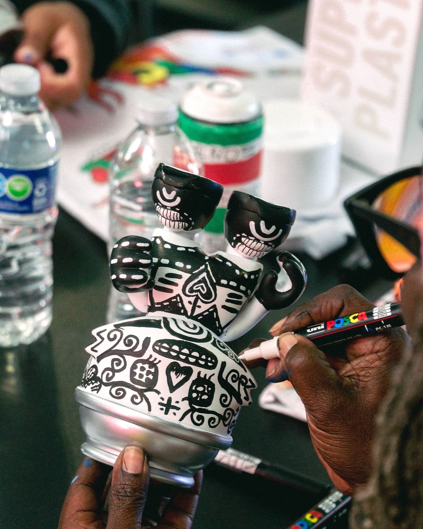 Workshop attendee using a POSCA marker to customize a vinyl toy figure during a Secret Walls X POSCA workshop (Photo: Emmett Methven)