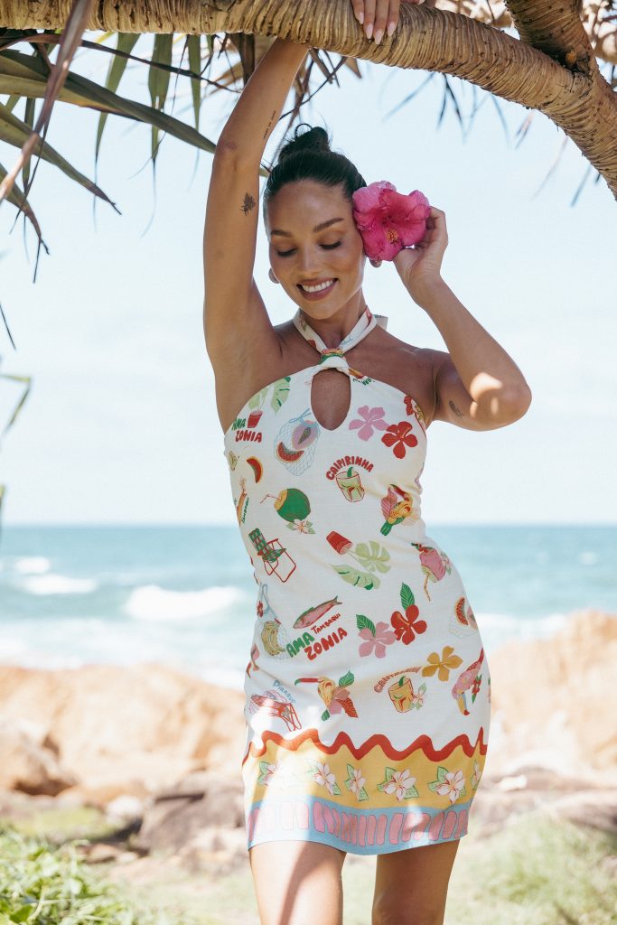 OCTAVIA MINI DRESS - ALFRESCO
 Featuring a halter neckline with an elegant tie closure and a daring backless design, this dress is all about effortless confidence. The vibrant tropical print brings summer vibes to your wardrobe, making it perfect for everything from rooftop cocktails to beachside dinners.